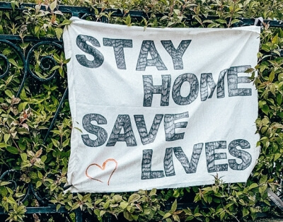 stay home save lives banner on fence