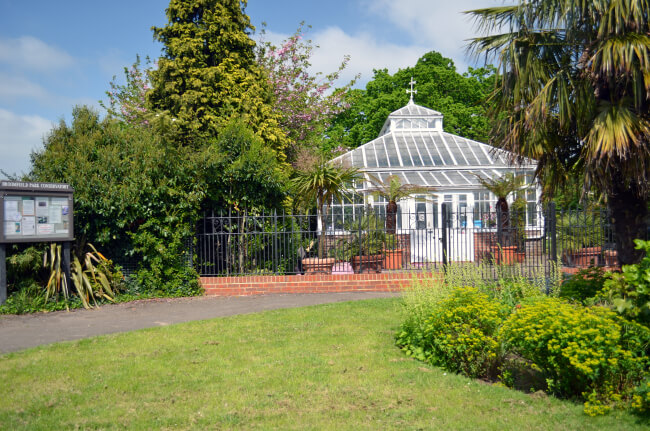 photo of Broomfield Conservatory behind railings showing flower bed in foreground