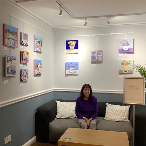 Mary Horsfield at the Southgate Gallery with examples of her paintings on the walls