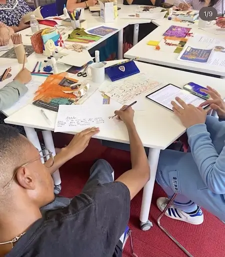 people sitting round tables during a people with voices poetry session