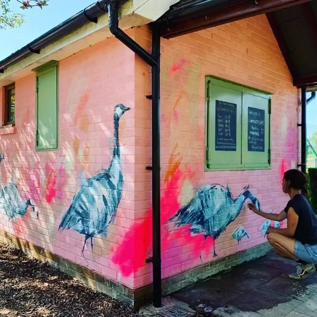 artist laura mckendry painting canada geese mural on palmers greenery cafe