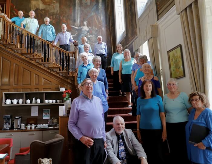 members of enfield in song choir standing on the staircase at the beaumont care home southgate